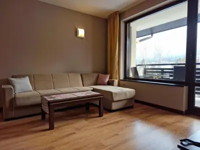 a living room with a couch and a table and a window at Apartaments by Zenit in Terra Complex B16 and D09 near Bansko in Razlog