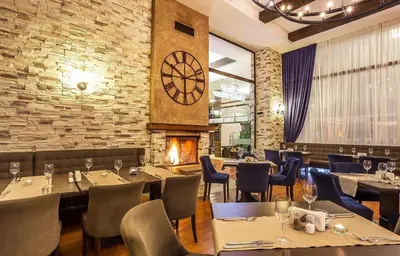 a restaurant with tables and chairs and a large clock at Apartaments by Zenit in Terra Complex B16 and D09 near Bansko in Razlog