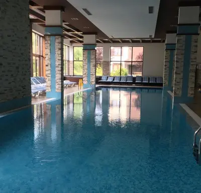 a swimming pool with blue water in a building at Apartaments by Zenit in Terra Complex B16 and D09 near Bansko in Razlog