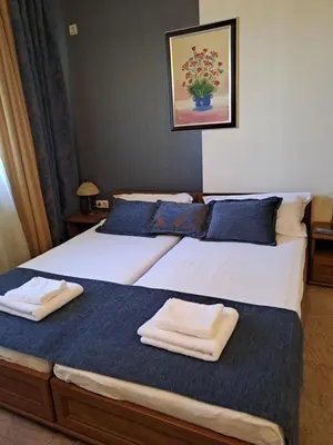 two beds in a room with towels on them at Annett apartments at Emerald hotel in Bansko
