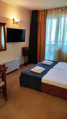 a bedroom with a bed and a flat screen tv at Annett apartments at Emerald hotel in Bansko