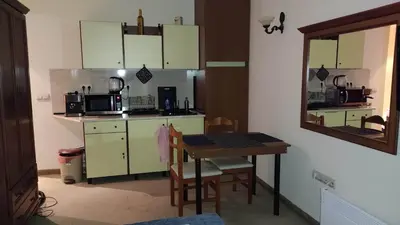 a small kitchen with a table and a microwave at Annett apartments at Emerald hotel in Bansko