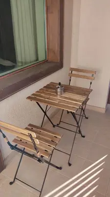 a wooden table and a bench sitting next to a window at Annett apartments at Emerald hotel in Bansko