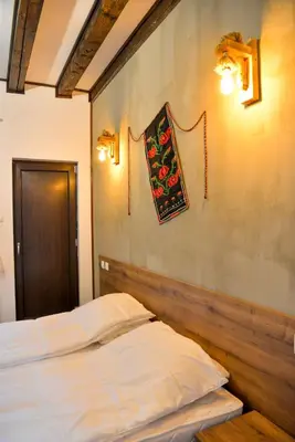 a bedroom with a bed and a wall with a picture at Къщи за гости НЕСИ in Leshten