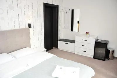 a bedroom with a white bed and a dresser at Bóris House in Ognyanovo