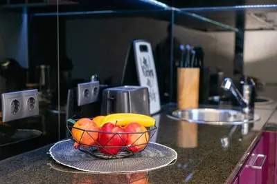 a bowl of fruit on a counter in a kitchen at Warm&Cozy Studio with Patio in Bansko