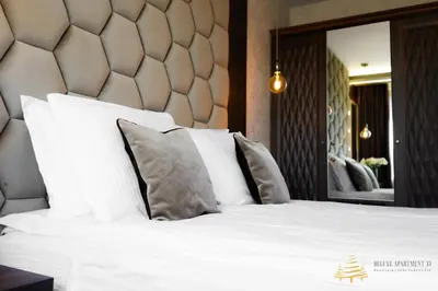 a bedroom with a bed with white sheets and pillows at Deluxe Apartment 33 Mountain Lodge Pamporovo in Pamporovo