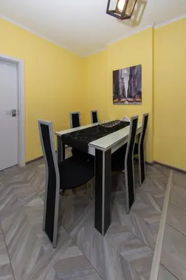 a dining room with a black table and chairs at The yellow appartment in Sofia