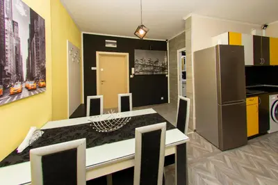 a kitchen with a refrigerator and a table and chairs at The yellow appartment in Sofia