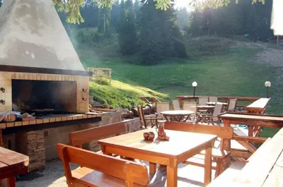a outdoor patio with a fireplace and tables and chairs at Форест Нук - апартамент in Pamporovo