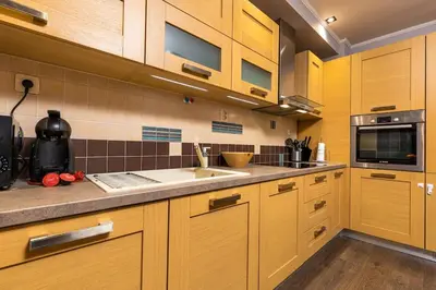 a kitchen with wooden cabinets and a sink at Dufti Home in Plovdiv Center & Old Town / Kapana in Plovdiv