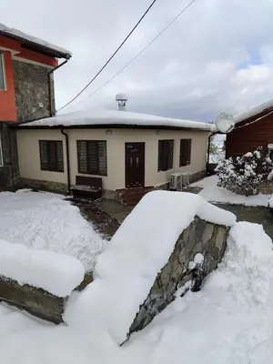 a house with a pile of snow in front of it at Къща за гости Елит (Guest House Elite) in Sapareva Banya