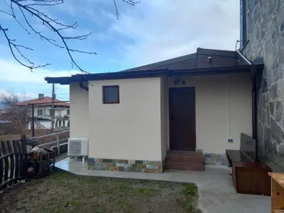 a small white house with a brown door at Къща за гости Елит (Guest House Elite) in Sapareva Banya