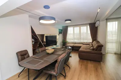 a living room with a table and a couch at Gran Capital Top Central Apartment in Sofia
