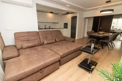 a living room with a brown couch and a table at Gran Capital Top Central Apartment in Sofia