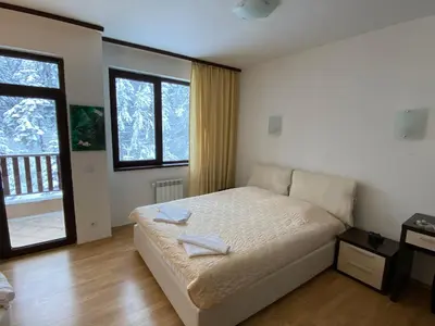 a bedroom with a bed with two towels on it at Charming Winter Studio in Borovets