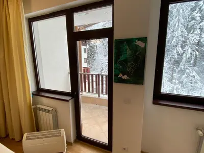 a room with a window and a view of a balcony at Charming Winter Studio in Borovets