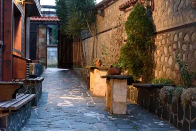 a stone walkway with benches on the side of a building at Cosy room in the center of Bansko in Bansko