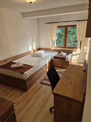 a bedroom with two beds and a desk and a chair at самостоятелна къща Планински перли, дом 1 на 5 мин от ски лифт Стойките, Пампорово in Stoykite