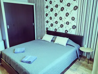 a bedroom with a bed with two towels on it at Alexander Apartments Kyustendil in Kyustendil