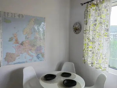 a table and chairs in a room with a map at Alexander Apartments Kyustendil in Kyustendil