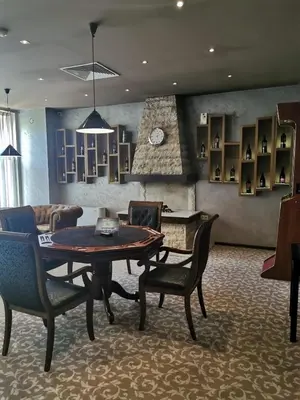 a living room with a table and chairs and a fireplace at Suite Roma 1 at Royal Spa in Velingrad