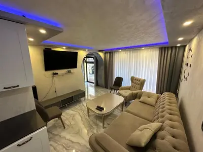 a living room with a couch and a tv at Apartments Dream in Sarnitsa