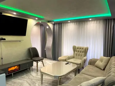 a living room with a tv and a couch and chairs at Apartments Dream in Sarnitsa