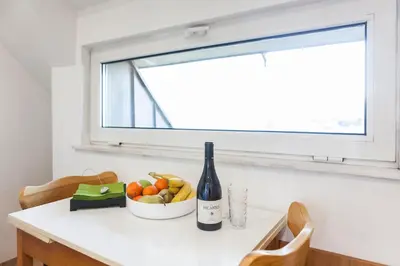 a bottle of wine and a bowl of fruit on a kitchen counter at Tony's Sunny Rooftop Studio by Flat Mаnager in Sofia