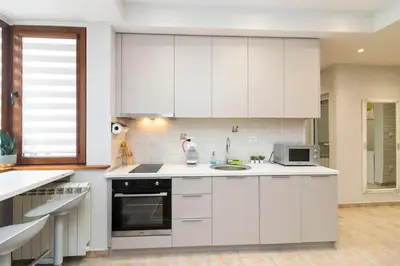 a white kitchen with white cabinets and a microwave at Spacious Aristocratic Apt. with a Colourful View in Sofia
