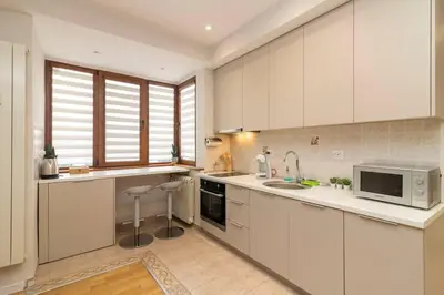 a kitchen with white cabinets and a sink and a microwave at Spacious Aristocratic Apt. with a Colourful View in Sofia