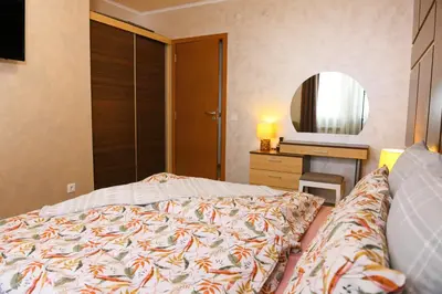 a bedroom with a bed and a dresser and a mirror at Apartment Svetoslava in Pamporovo