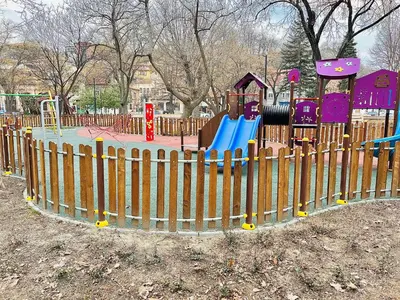 a playground in a park with a wooden fence at Elegant Stay in the Heart of Plovdiv Old Town in Plovdiv