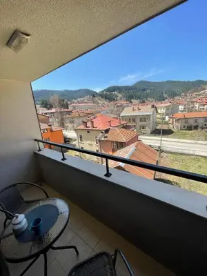 a view from a balcony with a table and chairs at Апартамент РАЯ in Chepelare