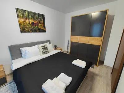 a bedroom with a large bed with two towels on it at Апартамент РАЯ in Chepelare
