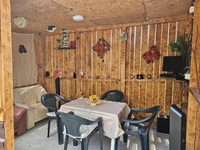 a dining room with a table and chairs and a tv at Апартамент за гости Криси гр. Девин in Devin