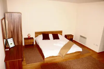 a bedroom with a bed with white sheets and brown pillows at Pirin Palace in Bansko