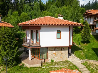 a small white house with an orange roof at Pamporovo Cottage Savov in Pamporovo