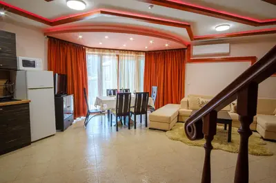 a living room with a kitchen and a dining room at Pamporovo Cottage Savov in Pamporovo