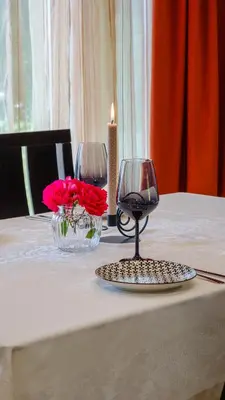 a table with two wine glasses and flowers on it at Pamporovo Cottage Savov in Pamporovo