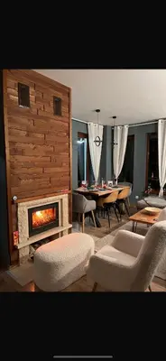 a living room with a fireplace and a table at Cozy Apartment B35 in Grand Resort Pamporovo in Pamporovo