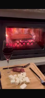 a glass of wine and cheese in front of an oven at Cozy Apartment B35 in Grand Resort Pamporovo in Pamporovo