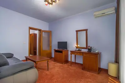 a living room with a couch and a desk with a tv at Парк-Хотел Клементина in Trud