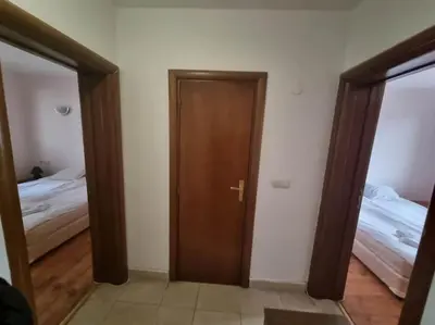 a room with two beds and a wooden door at Private Chalets Bansko in Bansko