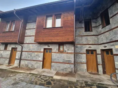 an old stone building with wooden doors and windows at Private Chalets Bansko in Bansko
