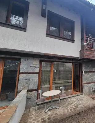 a table and two chairs in front of a building at Private Chalets Bansko in Bansko