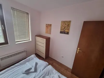 a bedroom with a bed and a dresser and a door at Private Chalets Bansko in Bansko