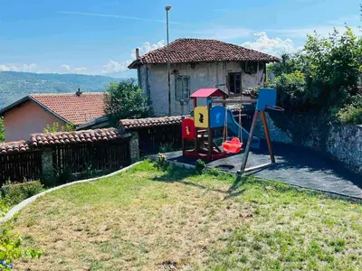 a playground in a yard next to a house at Къща за гости Под Манастира in Skrino