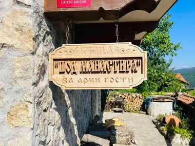 a sign hanging from the side of a building at Къща за гости Под Манастира in Skrino