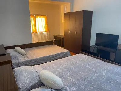 a hotel room with two beds and a flat screen tv at Alpin Guest House in Sapareva Banya